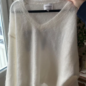 Vit tröja från American Dreams - Säljer en fluffig vit tröja från American Dreams med blå text 'LOVE' på ryggen. Tröjan har en v-ringad hals som kan glida ner på axeln om man så vill. Köpt för 1200kr. 