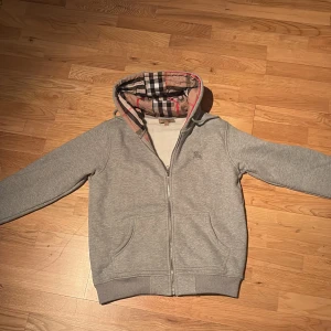 Grå huvtröja från Burberry - Säljer min burberry hoodie för den är lite för stor för mig och jag använder den inte. Storlek M med passar S också. Jag har använt denna 1 gång. Den är väldigt varm och skön! Så perfekt för vinter. Den har ett litet hål men inget som man märker! Hör av er vid frågor! Mvh albin 