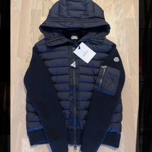 Moncler cardigan jacka - Säljer en väldigt snygg mörkblå moncler cardigan jacka för att den är för liten. Den är använd ett fåtal gånger så den är i jättebra skick. Jackan är storlek L men skulle säga att den passar M. Är det något du undrar över eller om du vill ha fler bilder så tveka få inte att höra av dig!😃