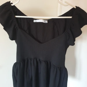 Svart topp från lager 157🤩 - Säljer en svart topp från lager 157 med volangdetaljer och v-ringning. Använd fåtal gånger, hör av er vid frågor!🙌🏼