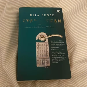 Städerskan av Nita Prose - Säljer boken 'Städerskan' av Nita Prose, utgiven av Albert Bonniers Förlag. En spännande thriller som vann Goodreads Best Mystery & Thrillers 2022. Perfekt för dig som älskar mysterier och intriger. Boken är i pocketformat och har en stilren omslagsdesign med en dörrhandtag och byggnad. Bra skick utöver att titeln försvunnit mestadels