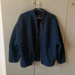 Mörkblå teddyjacka från Zara - Säljer en mysig mörkblå teddyjacka från Zara. Jackan har en dragkedja framtill och långa ärmar. Kom gärna med prisförslag!❤️