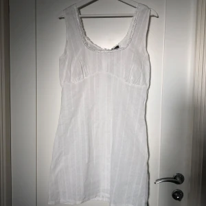 Vit klänning från Boohoo - Säljer en söt vit klänning från Boohoo med spetsdetaljer vid halsringningen, perfekt för student eller avslutning! Aldrig använd endast testad.