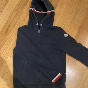 Moncler zip - Nu säljer jag min moncler zip hoodie. Den är tvär snygg med ränderna runt luvan och ärmarna. Den är storlek S och märket funkar att scanna. Priset är inte ristat i sten så kom gärna med bud!!