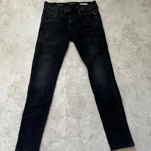 Svarta jeansbyxor från Replay - Snygga svarta jeansbyxor från Replay med en slim passform. Byxorna har en klassisk femficksdesign och en knappgylf. Perfekta för en stilren look.
