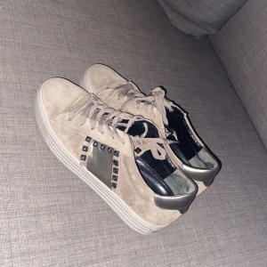 Beige sneakers med nitar från Kenneth Cole - Snygga beige sneakers i mocka från Kennel Schmenger. I storlek 37-38. Skriv för fler bilder eller frågor🥰 pris kan diskuteras vid snabbaffär!