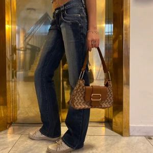 Axelremsväska  - Snygg axelremsväska med guldiga detaljer och  ett väldigt stilrent mönster 