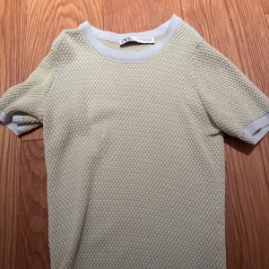 Gul och turkos  stickad topp från Zara - Säljer en söt gul och turkos  stickad topp från Zara. Den har korta ärmar och ett prickigt mönster❤️har sytt igen ett hål som ni kan se på andra bilden !