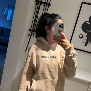 Beige hoodie med tryck - Säljer en beige hoodie med texttryck på framsidan. Den har en klassisk design med en stor huva och långa ärmar. Perfekt för en avslappnad stil.