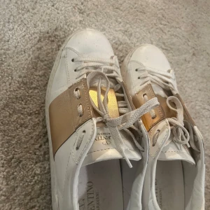 Valentino Garavani sneakers i vitt och guld - Snygga Valentino Garavani sneakers i vitt med gulddetaljer. Bra skick, använda några få gånger❤️
