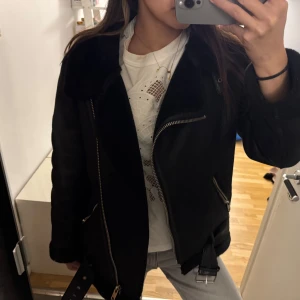 Svart jacka från Zara - Snygg svart jacka från Zara med dragkedja och bälte. Perfekt för kyligare dagar med sin stilrena design och bekväma passform. Jackan har långa ärmar och en mjuk insida som håller dig varm. Ett måste i garderoben för en trendig look!