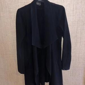 Svart lång kappa från Only - Snygg svart lång kappa från Only med en elegant draperad krage. 