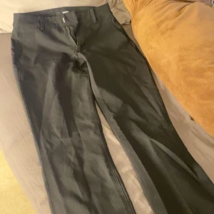 Svarta kostymbyxor från BikBok - Snygga svarta kostymbyxor från BikBok i storlek 34. De har slits där nere 