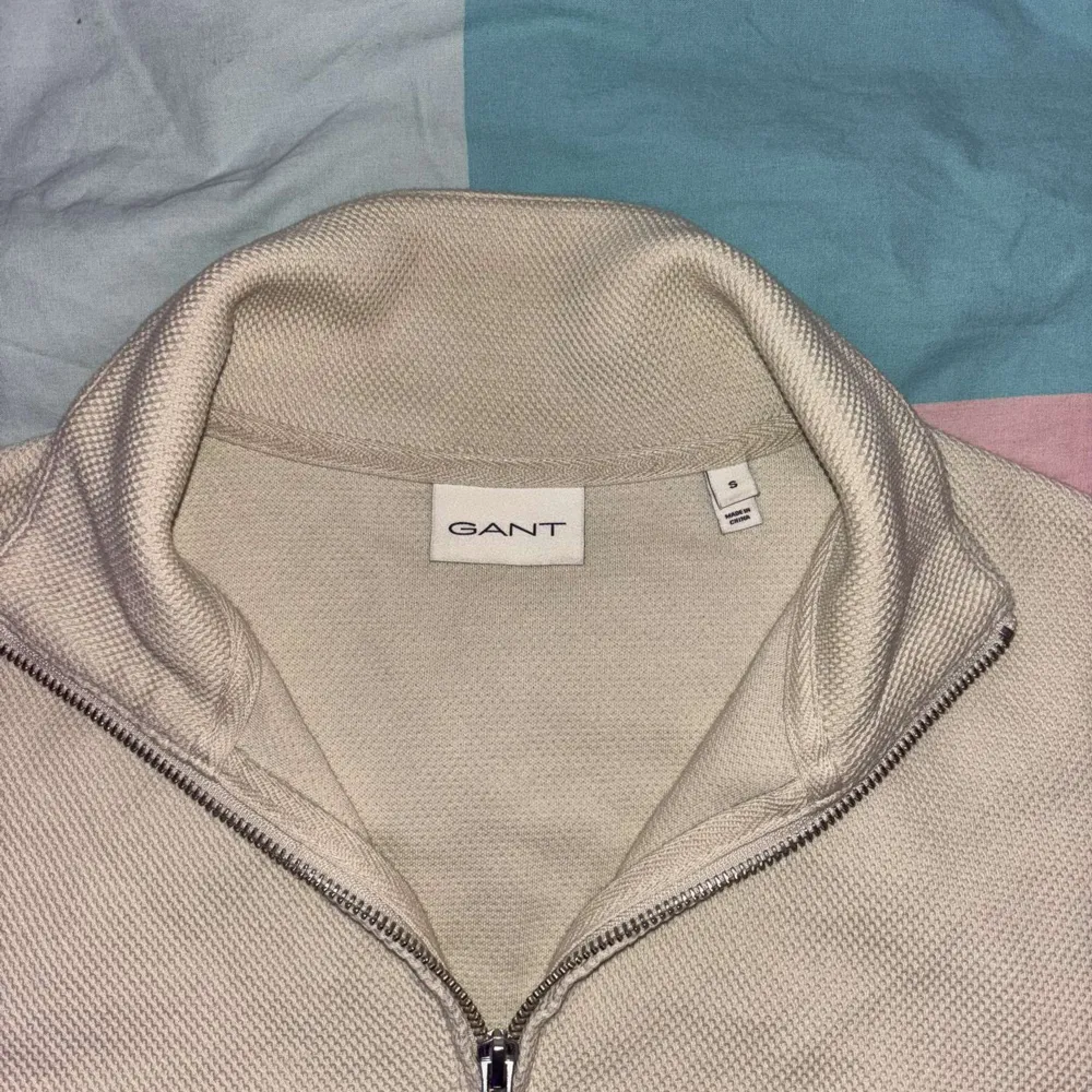 Säljer en stilren beige tröja från GANT med halv dragkedja. Tröjan har en klassisk design med långa ärmar och ribbade muddar. Perfekt för en avslappnad och snygg look. Använd en gång, var fel storlek. Kostar 1400 ny. . Neuletakit & Villapaidat.