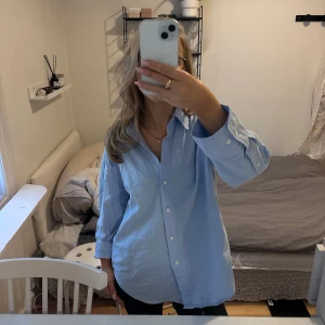 Blå skjorta från Zara - Säljer en stilren blå skjorta från Zara i storlek XS. Skjortan har långa ärmar och knappar framtill. Perfekt för en avslappnad men ändå snygg look. Knappt använd. Nypris: 399 💞(tröjan är ej struken på bilden)