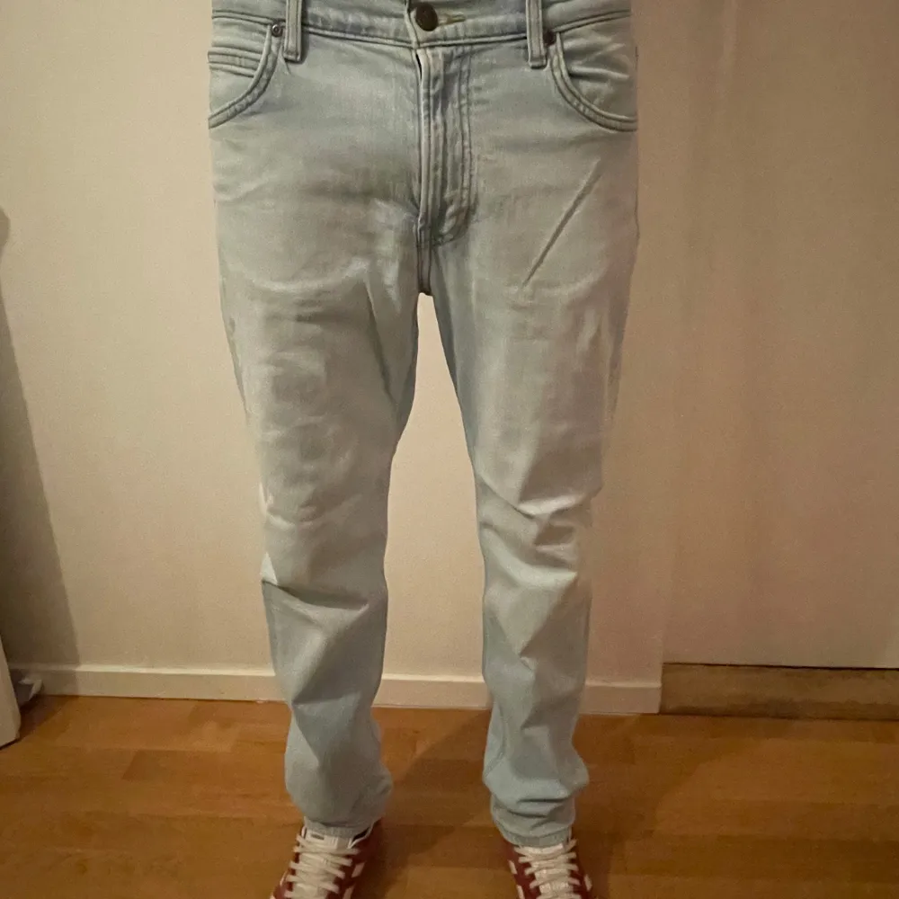 Snygga ljusblå jeans från Lee med en klassisk femficksdesign. De har en straight passform och är tillverkade i ett bekvämt denimtyg. Köpte jeansen på carlings för 999kr. Byxorna är som nya. 10/10 skick helt enkelt. Om du har frågor eller funderingar är det bara att höra av dig. Priset är inte hugget i sten.. Farkut & Housut.