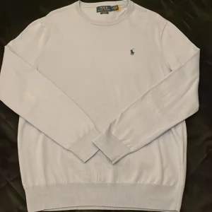 Ljusblå tröja från Polo Ralph Lauren - Säljer en stilren ljusblå tröja från Polo Ralph Lauren i slim fit. Tröjan har en diskret broderad logga på bröstet och är tillverkad i ett mjukt material. Perfekt för en klassisk och avslappnad look. Kan gå ner i pris vid snabb affär
