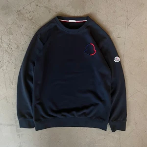 Moncler tröja - Säljer en mörkblå Moncler-tröja i utmärkt skick. Tröjan har endast använts ett fåtal gånger och är som ny.  Storleken passar inte mig längre, så nu får någon annan chansen att använda den. Vid behov skickar jag gärna exakta mått – hör av dig om du är intresserad!  Bra kvalitet!