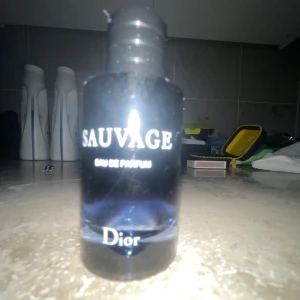 Sauvage Eau de Parfum från Dior - Säljer en flaska Sauvage Eau de Parfum från Dior. Flaskan har en elegant design med en mörkblå ton som övergår till klar vid botten. Perfekt för den som söker en sofistikerad och maskulin doft. Nästan hel full hör av er, Säljer par ingen användning