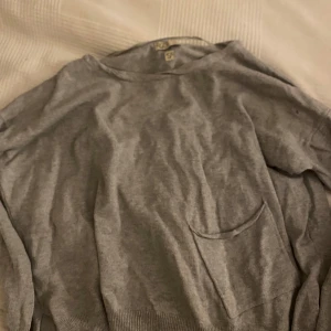 Grå vintage tröja från R&D - Säljer en enkel och skit cool vintage tröja!! Stilren grå tröja från R&D. Tröjan har en rund hals och en praktisk ficka på framsidan. Perfekt för en avslappnad look. Pris kan diskuteras
