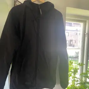 Säljer ”C.P. COMPANY FLATT NYLON HOODED LENS JACKET” i storlek 48(sitter som M), knappt använd, väldigt bra skick!   Mitt pris: 1900