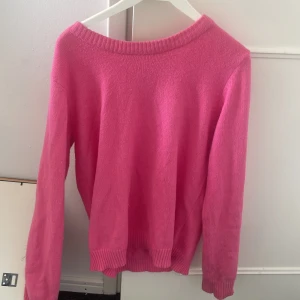 Rosa stickad tröja - Säljer en superfin rosa stickad tröja som är perfekt för kyligare dagar. Den har en enkel design med långa ärmar och ribbade kanter vid hals, ärmslut och nederkant. Passar både till vardags och lite mer uppklädda tillfällen. 💖