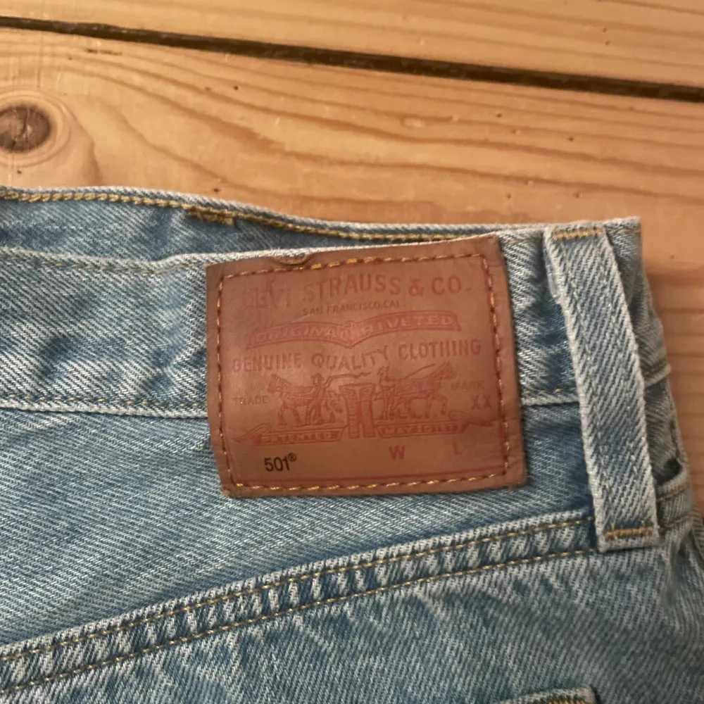 Säljer ett par coola jeansshorts från Levi's i ljusblå denim. De har en klassisk femficksdesign och är avklippta med råa kanter för en avslappnad look. Perfekta för sommardagar eller festivaler!. Shorts.