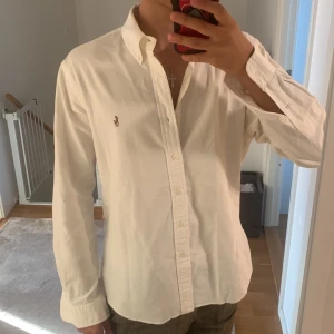 Ralph Lauren Skjorta Oxford White - Vit Ralph Lauren skjorta i stl L slim fit med långa ärmar och en liten polospelare broderad på bröstet. Super skick, orginalpris 1499 kr men säljer endast för 449 kr. Om du har frågor är det bara att kontakta mig.