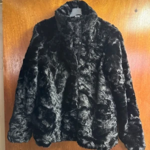 Svart pälsjacka - Helt ny svart jacka i fuskpäls. Jackan är endast provad och passar mig som bär XS/S i ytterkläder. Observera dock att jackan är i barnstorlek (158).