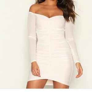 Vit offshoulder klänning - Snygg vit offshoulder klänning med långärmade transparenta ärmar och en tight passform. Klänningen har en v-ringad design och är perfekt för en stilren look. Den korta längden ger en modern touch.