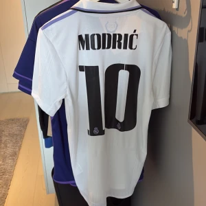 Real Madrid Authentic 22/23 kit ”Modric 10” - Real Madrid authentic player version kit från Adidas med Modric och nummer 10 på ryggen. 120 års jubileum. Använd max 10 gånger. Äkta, köpt i Madrid i deras official store. 