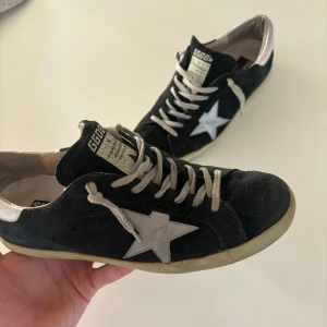 Golden goose - Hej!👋 jag säljer ett par stilrena Snygga svarta golden goose som självklart är äkta! Skornas skick är 7/10 där den enda defekter är hälen bild 5. Detta är dock vanligt vid golden goose och det är absolut inget hål till innersulan alltså kan vatten inte komma in osv Priset är diskuterbart vid snabb affär. Skriv vid minsta fundering🤝👊