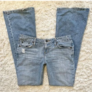Blå bootcut low waist jeans - Snygga blå bootcut jeans med fina unika detaljer. Lågmidjade och bootcut och knappt använda av mig. Skriv gärna om du undrar något❤️storlek xs/s