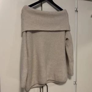  offshoulder tröja  - Säljer en mysig beige stickad tröja från H&M i jätte bra sick med offshoulder-design. Perfekt för kyliga dagar med sin mjuka och bekväma passform. Tröjan har långa ärmar och en bred krage som ger en stilren look. Passar utmärkt till både jeans och kjol.💕