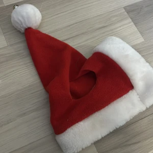 Röd enöras julhuva 🌲 - Säljer en klassisk röd tomteluva med vit kant och en vit tofs på toppen med en liten plinga. Perfekt för julen. 🎅denna är använd typ 3 gånger