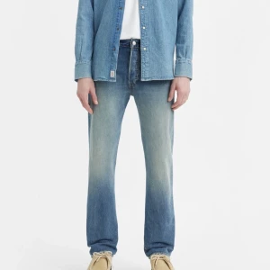 Levis 501 jeans - Klassiska Levis 501 jeans i en snygg blå tvätt. De har en rak passform och är tillverkade i slitstarkt denim. Perfekta för en avslappnad stil med knappgylf och fem fickor. 
