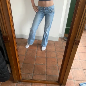 Ljusblå bootcut jeans - Snygga ljusblå jeans med bootcut-stil och låg midja. Andvänt sparsamt Midjemått:33 midjan går att justera Innerbenslängd:73