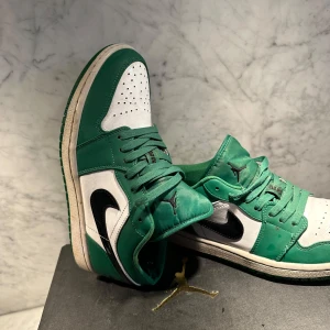 Gröna och vita JORDAN 1 "PINE GREEN" LOW - Snygga gröna och vita Nike Air Jordans med svart swoosh och snörning. Perfekta för att sticka ut med en klassisk stil. Ny pris 6499 kr