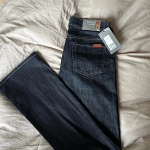 Mörkblå bootcut jeans från 7 for All Mankind - Snygga mörkblå bootcut jeans från 7 for All Mankind. Dessa jeans är jättesnygga, men måste tyvärr sälja dem då de är för små för mig. Perfekta för alla tillfällen och är helt nya med prislapp!!!