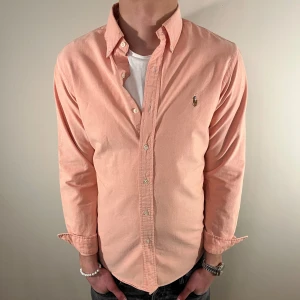 Orange/rosa Ralph Lauren skjorta - Nu säljer vi ännu en fet polo skjorta som passar till alla tillställningar!🔥Den har ett ytterst litet fel i ärmen(bild 4) vilket gör att vi sänker priset!Du ska kunna uttrycka stil utan att det kostar för mycket!🕺🍾💼🤩  Storlek👔: M Nypris💰:  ca 1499kr