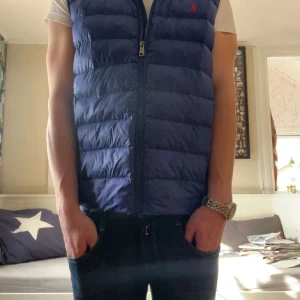 Ralph Lauren väst - Säljer denna schyssta västen från Ralph lauren! Det finns inget fel med den förutom någon enstaka tråd som hänger från dragkedjan. Nypriss:1500kr 