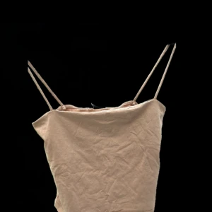 Beige linnetopp från Gina Tricot - Säljer en stilren beige linnetopp från Gina Tricot. Toppen har smala axelband och en enkel design som passar perfekt till sommaren. Perfekt för en avslappnad look.