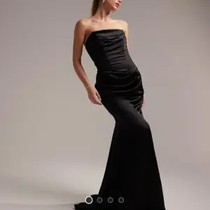 Elegant svart axelbandslös långklänning i ett glansigt material. Den va min bal klänning så hade på mig den bara en gång. Den är i perfekt skick. Perfekt för speciella tillfällen som bal och brudtärna. 