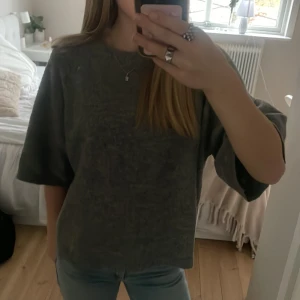 Grå stickad tröja - Mysig grå stickad tröja med trekvartsärm. Perfekt för kyligare dagar och ger en avslappnad look. Tröjan har en rund halsringning och är gjord i ett mjukt material som känns skönt mot huden.