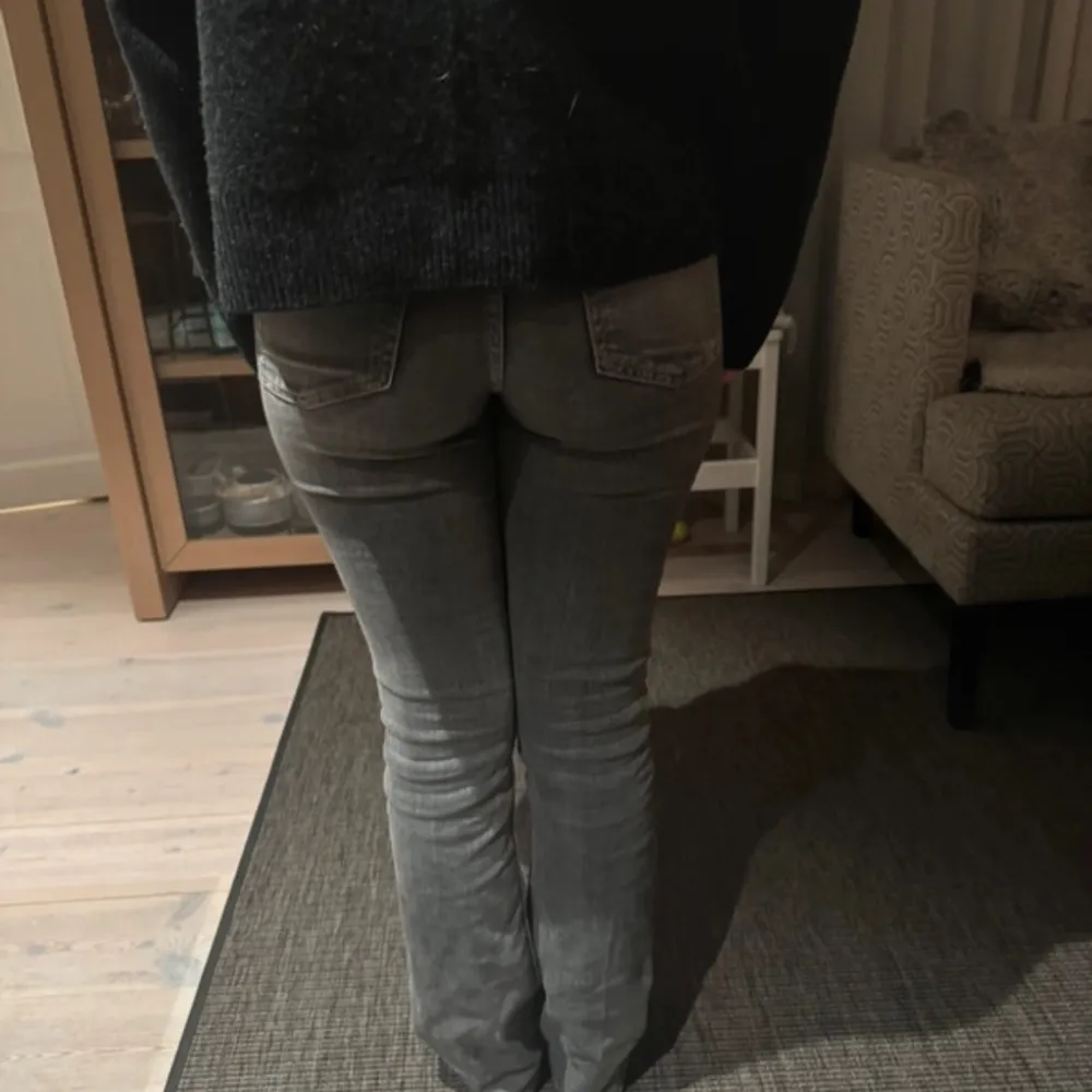 Snygga grå bootcut jeans med låg midja och klassisk femficksdesign. Perfekta för en avslappnad stil. De har en dragkedja och knapp framtill.. Farkut & Housut.