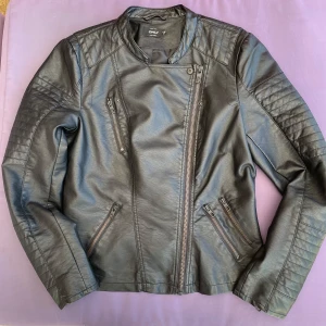 Svart skinnjacka från Only - Säljer en snygg svart skinnjacka från Only. Den har en cool asymmetrisk dragkedja och quiltade detaljer på axlarna och ärmarna. Perfekt för höst och vår! Jackan har en tight passform som ger en stilren look. Liten i storleken, mer som en 38:a. 