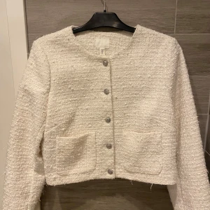 Vit cardigan med fickor - Säljer en vit cardigan med fickor, glittrig.  Säljer pågrund av att jag aldrig använt.  Jättefin💗💗 från Hm, dåligt ljus 