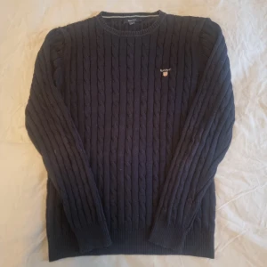 Gant kabelstickad tröja - Säljer en mörkblå gant hoodie i fint skick.