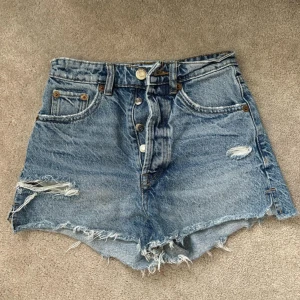 Zara high Rise blue jeans shorts - Högmidjade jeans shorts form zara. De är i storlek 32. Varan ör i väldigt bra skick då de är använda ett fåtal gånger.