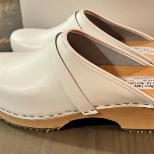Vita träskor från Boutique Kerskin Adolphson - Helt nya, oanvända träskor av Kerstin Adolphson med äkta läder  Färg: vit  Storlek: 41  Skick: oanvända - helt nya Originalpris: €79